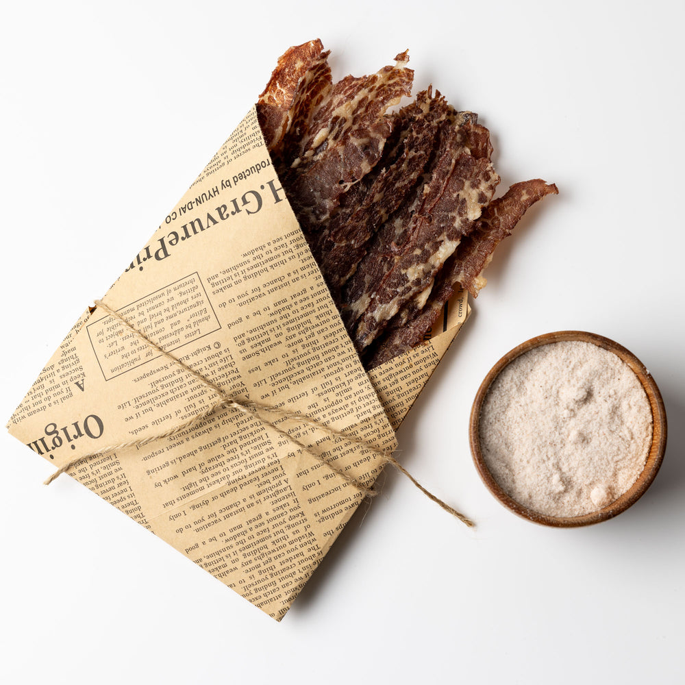 Sliced brisket beef chips served on parchment napkin with pinch of salt – kosher, high-protein snack display